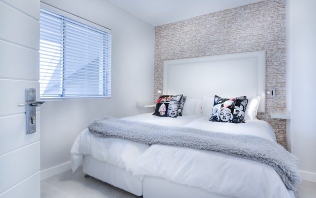 Apartments in Sugar Land A white bedroom with a white bed and white pillows in a two-bedroom apartment rental.